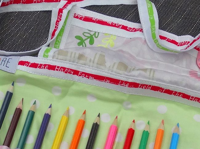 Childs apron with pencils in green and pink