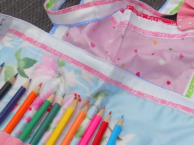 Childs apron with pencils in pink and blue